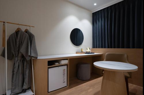 a room with a desk and a table in a room at No25 Hotel Naeoe in Gimhae