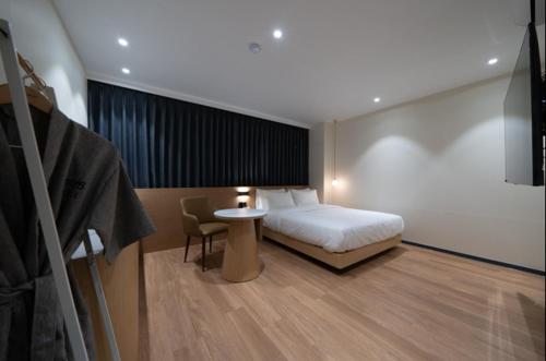 a bedroom with a bed and a table in a room at No25 Hotel Naeoe in Gimhae