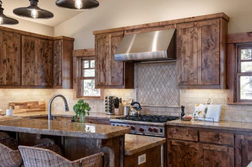 a kitchen with wooden cabinets and a stove at Atkinson by AvantStay Lake Front Home w Stunning Views in Tahoe Vista in Tahoe Vista