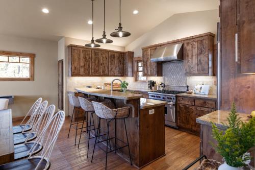 a kitchen with wooden cabinets and a large island with bar stools at Atkinson by AvantStay Lake Front Home w Stunning Views in Tahoe Vista in Tahoe Vista