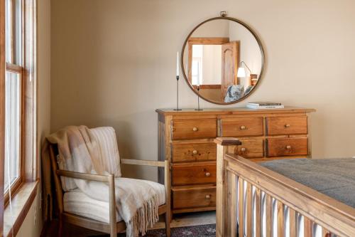 a bedroom with a dresser and a mirror and a chair at Atkinson by AvantStay Lake Front Home w Stunning Views in Tahoe Vista in Tahoe Vista