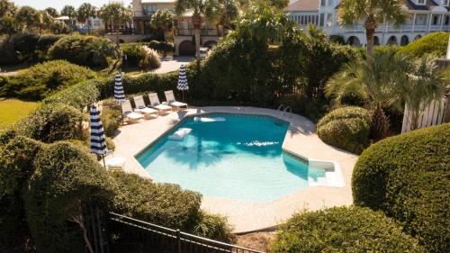 an overhead view of a swimming pool with chairs and trees at Haven by AvantStay Luxury Beachfront Home w Pool Gorgeous Patios in Sullivans Island