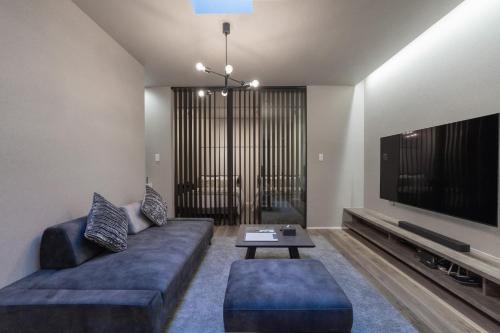 a living room with a couch and a flat screen tv at 西九条 Villa deLuxe - 高端设计奢华2卧一户建 可住6人 USJ电车5分 极致舒适体验 in Osaka