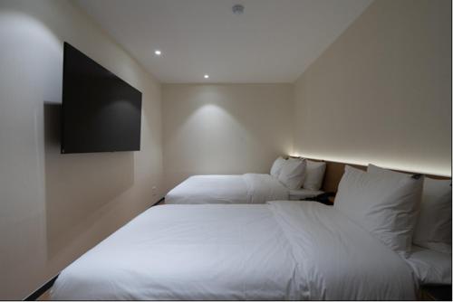 a hotel room with two beds and a flat screen tv at No25 Hotel Naeoe in Gimhae