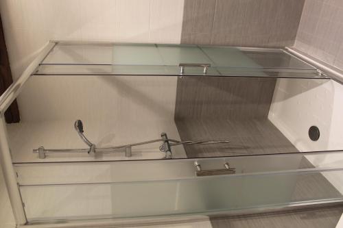 a glass shelf with a metal rail in a room at Pensión Manoli in Bilbao
