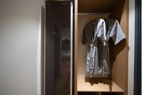 a room with a closet with a robe hanging on it at No25 Hotel Naeoe in Gimhae