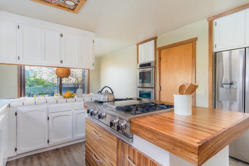 a kitchen with white cabinets and a stove at Gable by AvantStay Beautiful 3.5 Acre Oasis w Gorgeous Views Pool Hot Tub in Santa Rosa