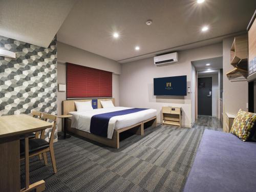 a hotel room with a bed and a tv at MONday Apart Hamamatsucho Daimon in Tokyo