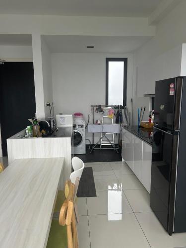 a kitchen with a black refrigerator and a table at Eco Nest 3 Bedroom Duplex Apartment in Nusajaya