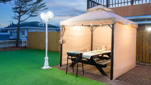a gazebo with a table and a lamp at Taean minoseu Pet Pension in Taean