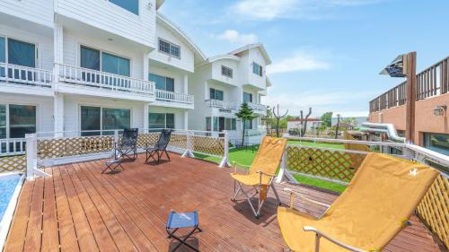 a large deck with chairs and a building at Taean minoseu Pet Pension in Taean