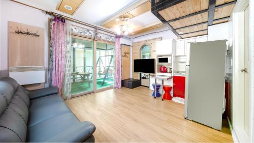 a living room with a couch and a television at Chuncheon thegangchon pension in Chuncheon