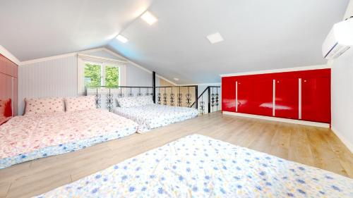 a bedroom with two beds and a red cabinet at Chuncheon thegangchon pension in Chuncheon