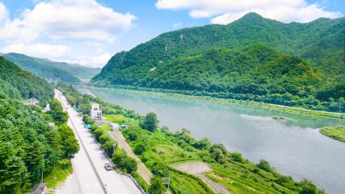 a view of a river with mountains in the background at Chuncheon thegangchon pension in Chuncheon
