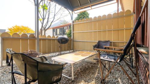 a screened porch with a table and chairs and a grill at GaPyeong Lucerne kids Spa Pension in Gapyeong