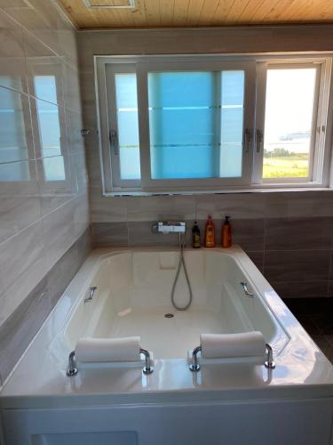 a large bath tub with two sinks in a bathroom at Ganghwa nolumog byeoljang in Incheon