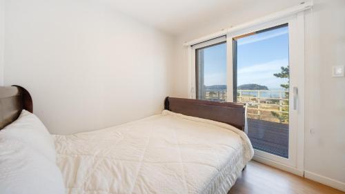 a bedroom with a bed and a large window at Boryeong Thirasel Pension in Boryeong