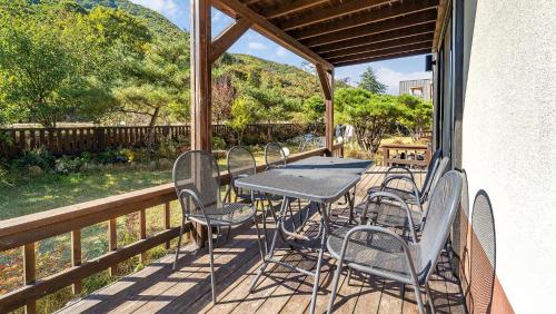 a patio with a table and chairs on a deck at Haneulbit Private Pool Villa, Gyeongju in Gyeongju