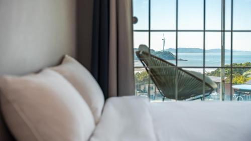 a room with a bed and a view of the ocean at Yeongheungdo noeul&bada pension in Incheon
