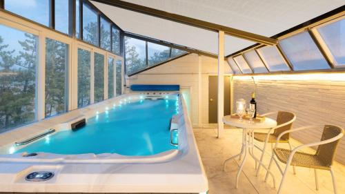 a swimming pool in a house with a table and chairs at Samcheok Migaloo Pool Villa Pension in Samcheok