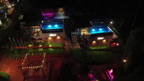un edificio con luces azules por la noche en Mannath Private Pool Villas at Vellarimala, en Wayanad