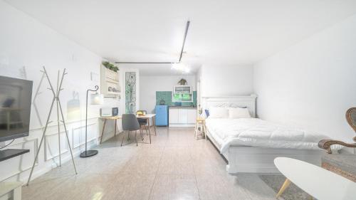 a white bedroom with a bed and a desk at Ganghwa Giverny Spa Pension in Incheon