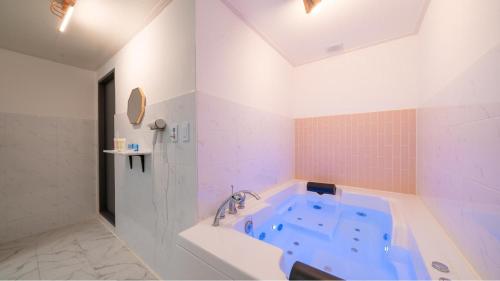 a bathroom with a blue tub in a room at GaPyeong Yeoldudal Spapension&Camping in Gapyeong