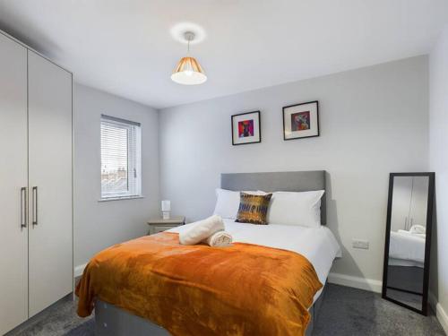 a bedroom with a large bed and a mirror at Cozy 2-Bed Belfast Apartment in Belfast
