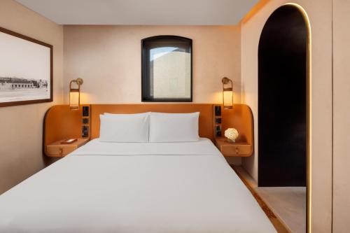 a bedroom with a large white bed and a window at The Chedi Hegra, AlUla in AlUla