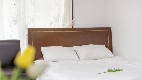 a bed with white pillows and a wooden headboard at Gapyeong Areuno Pet Pension in Gapyeong