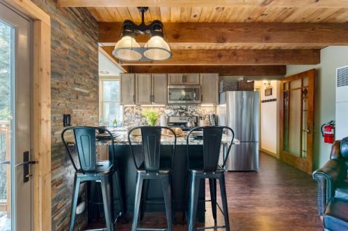 a kitchen with a bar with four stools at Jeffrey Pines Lofted Cabin Minutes to Lake A-Frame-Inspired Design Deck in Truckee