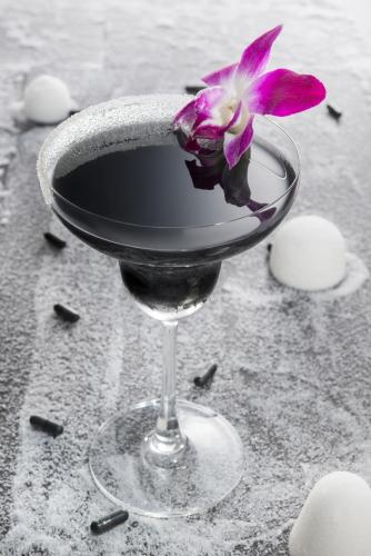 a purple flower sitting in a wine glass at Aauris in Kolkata