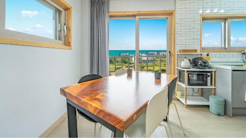 a kitchen with a wooden table and chairs and a window at Jeju Hoyeongfarm Stay in Jeju