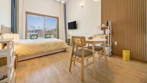 a bedroom with a bed and a table with a desk at Chuncheon Lio Pension in Chuncheon