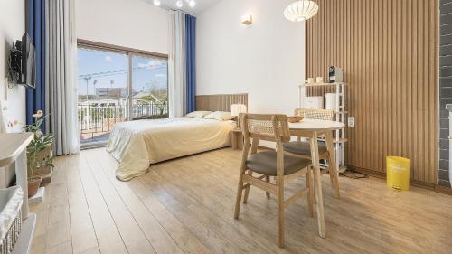 a bedroom with a bed and a desk and a table at Chuncheon Lio Pension in Chuncheon