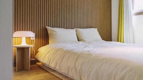 a bedroom with a white bed and a lamp at Chuncheon Lio Pension in Chuncheon