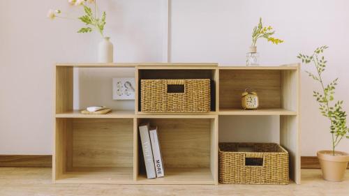 a wooden shelf with baskets on it in a room at Chuncheon Lio Pension in Chuncheon