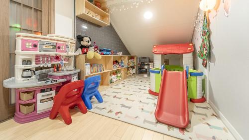 a play room with a slide and a play kitchen at Yangpyeong The On Private Kids Pension in Yangpyeong