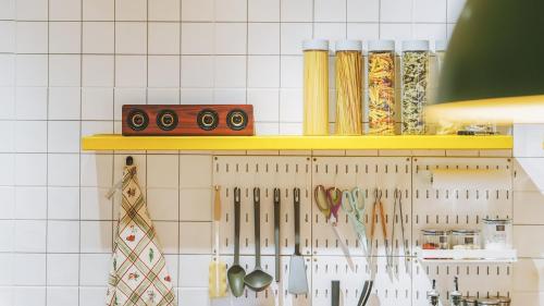a kitchen counter with a shelf with utensils at Yangpyeong The On Private Kids Pension in Yangpyeong