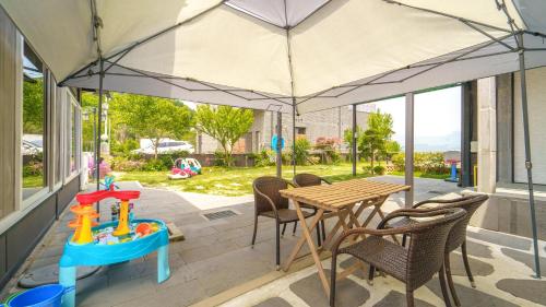 a patio with a table and chairs and an umbrella at Yangpyeong The On Private Kids Pension in Yangpyeong