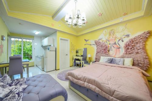 a bedroom with a large bed with a painting on the wall at Gapyeong Ashely Pension in Gapyeong