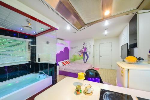 a room with a tub and a bed and a bathroom at Gapyeong Ashely Pension in Gapyeong