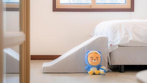 a toy doll sitting next to a hospital bed at Pocheon luxjay pet Pension in Pocheon