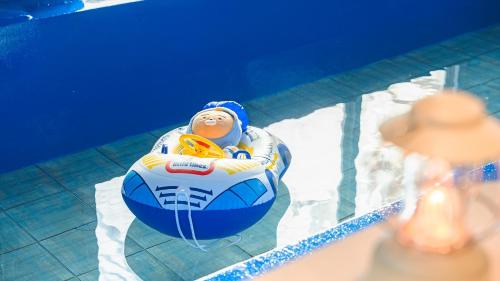 a baby in an inner tube in a swimming pool at Pocheon luxjay pet Pension in Pocheon