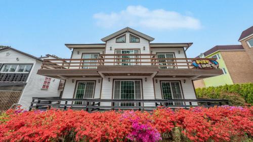 a house with flowers in front of it at Taean Mongsanpo and the Sea Pension in Taean