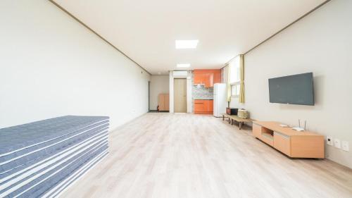 a large room with a bed and a flat screen tv at Tongyoung Sandeulhae Healling Pension in Tongyeong