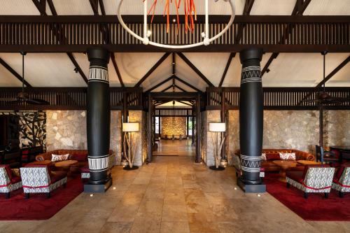 a large lobby with couches and a chandelier at Constance Lemuria in Grand'Anse Praslin