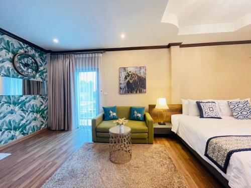 a hotel room with a bed and a couch at Romlaphass Boutique Villa in Kalasin