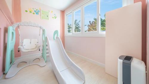 a childs room with a white chair and a mirror at Gyepngju Camino Pool Villa in Gyeongju