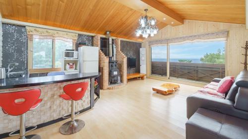 a kitchen and living room with a couch and a table at jeju oceancliffcottage in Jeju